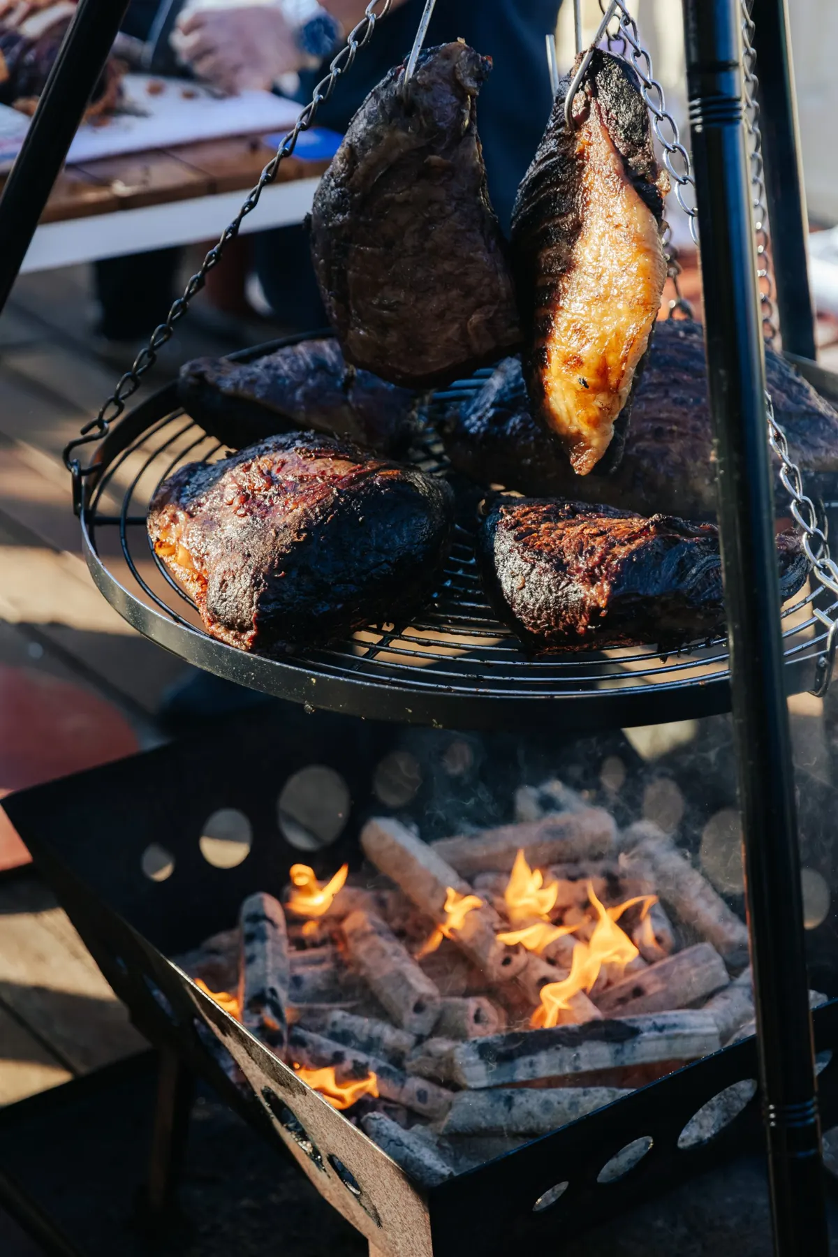 Cuts of meat cooking over an open fire